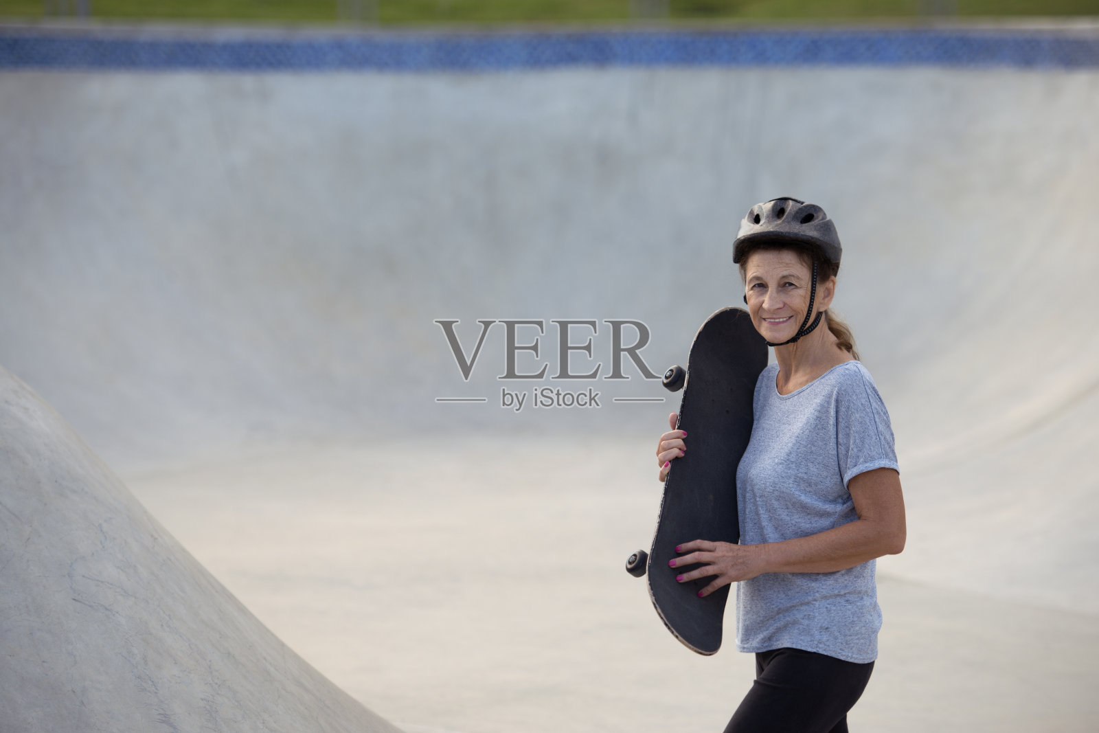 成年老年妇女学习新东西-骑滑板。照片摄影图片