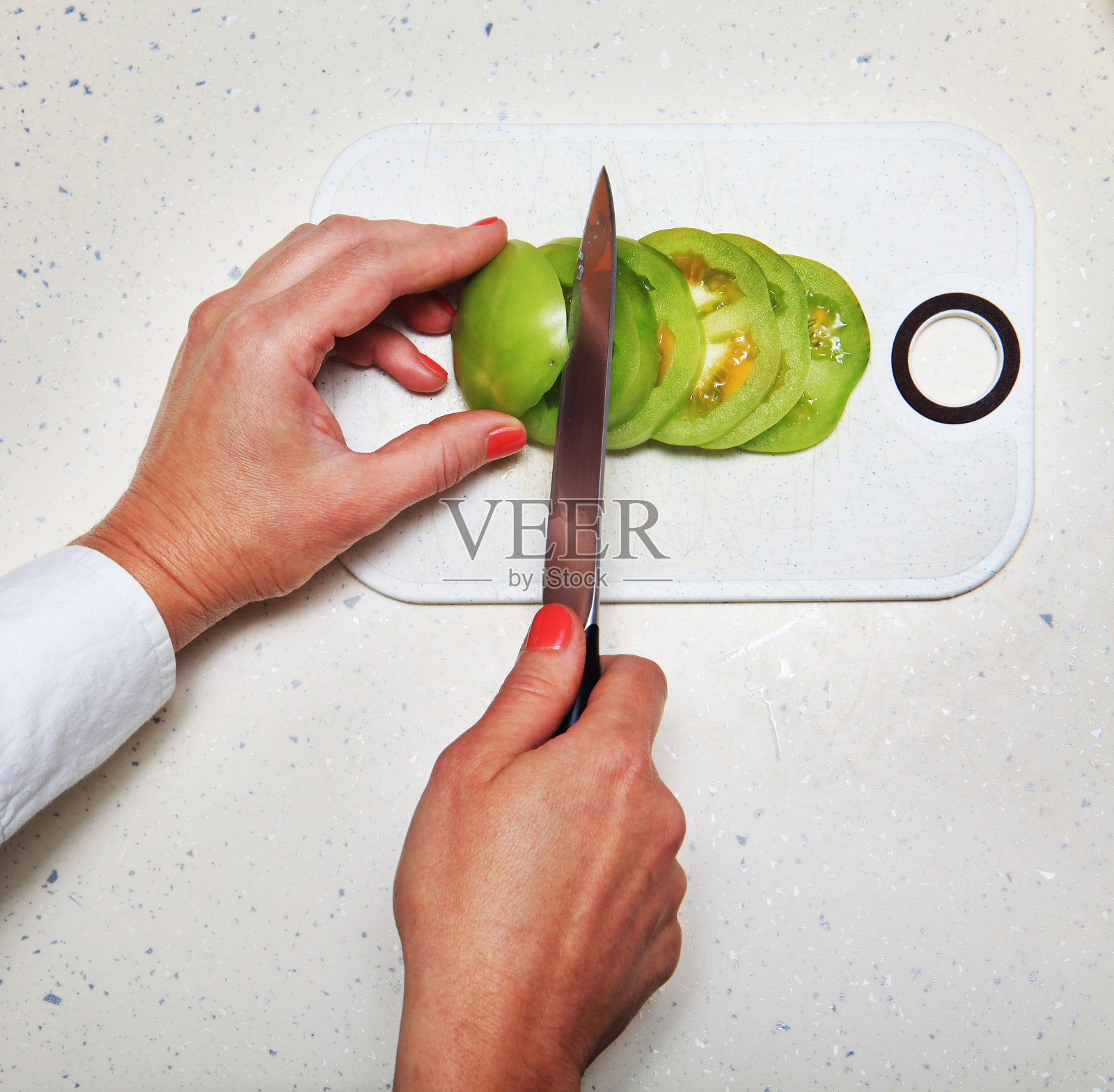 女人用手切西红柿照片摄影图片