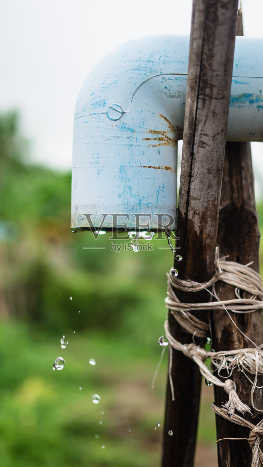 在雨天，水流通过古老的蓝色喷口照片摄影图片