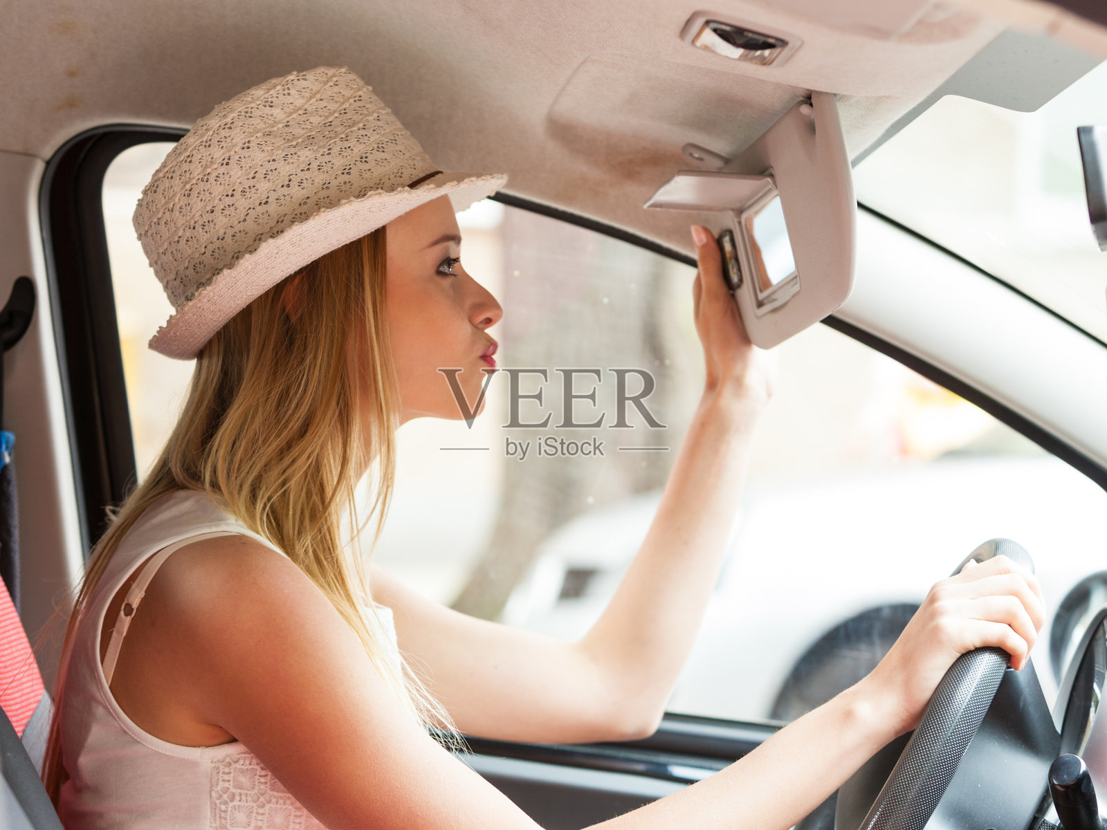 分心的女人看着镜子开车照片摄影图片