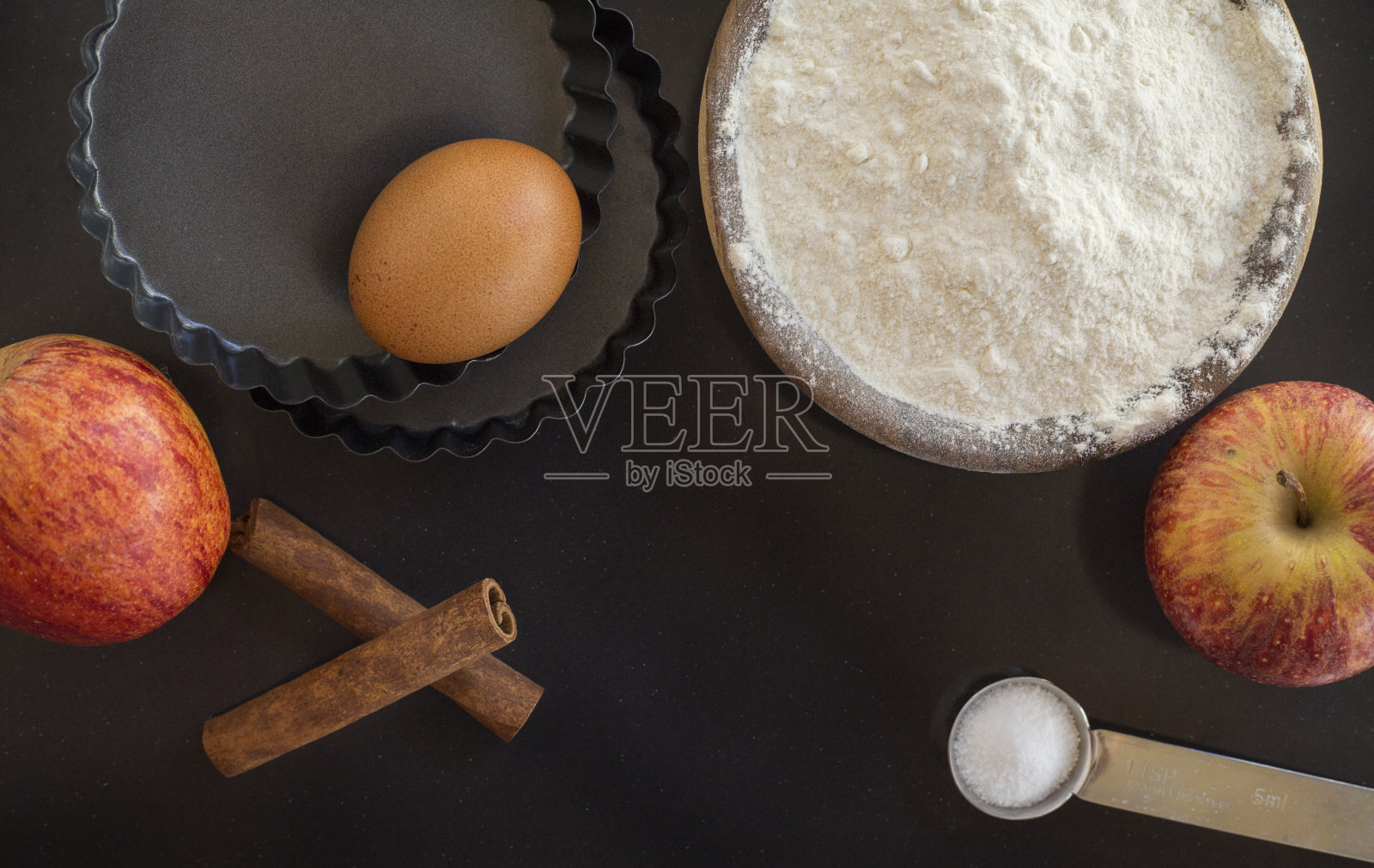 面粉和配料放在黑色的桌子上。俯视图照片摄影图片