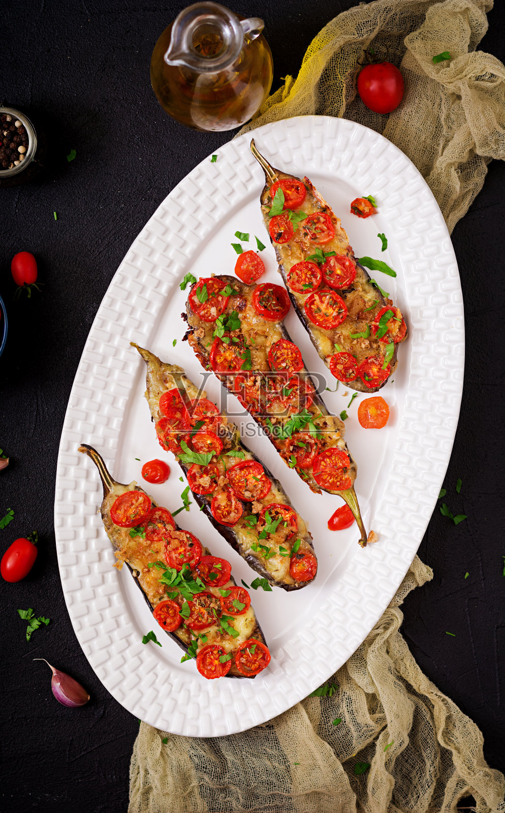 烤茄子配马苏里拉奶酪和番茄配意大利香草。平的。俯视图照片摄影图片