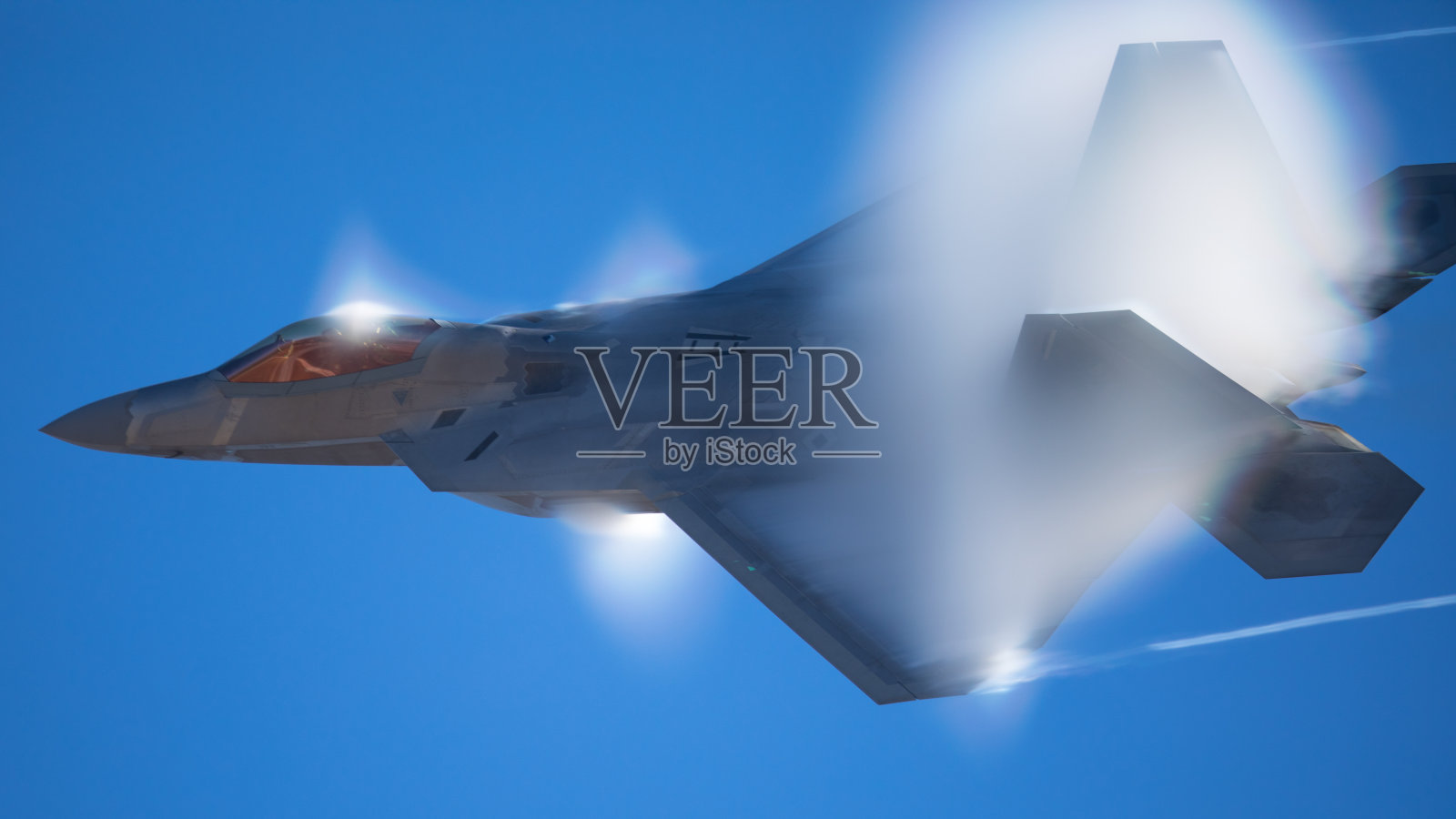 军用飞机在高g机动，与加力燃烧器，和凝结云和条纹周围的飞机..照片摄影图片