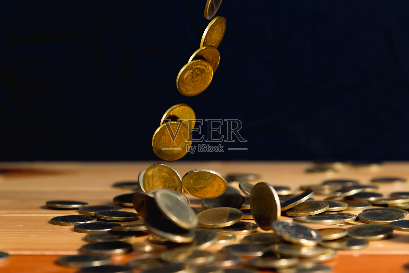 落金币钱木桌与黑墙，复制空间，商业财富概念。照片摄影图片