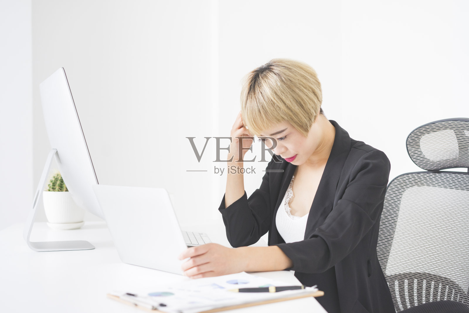 坐在办公桌前，感到压力的商务女性照片摄影图片