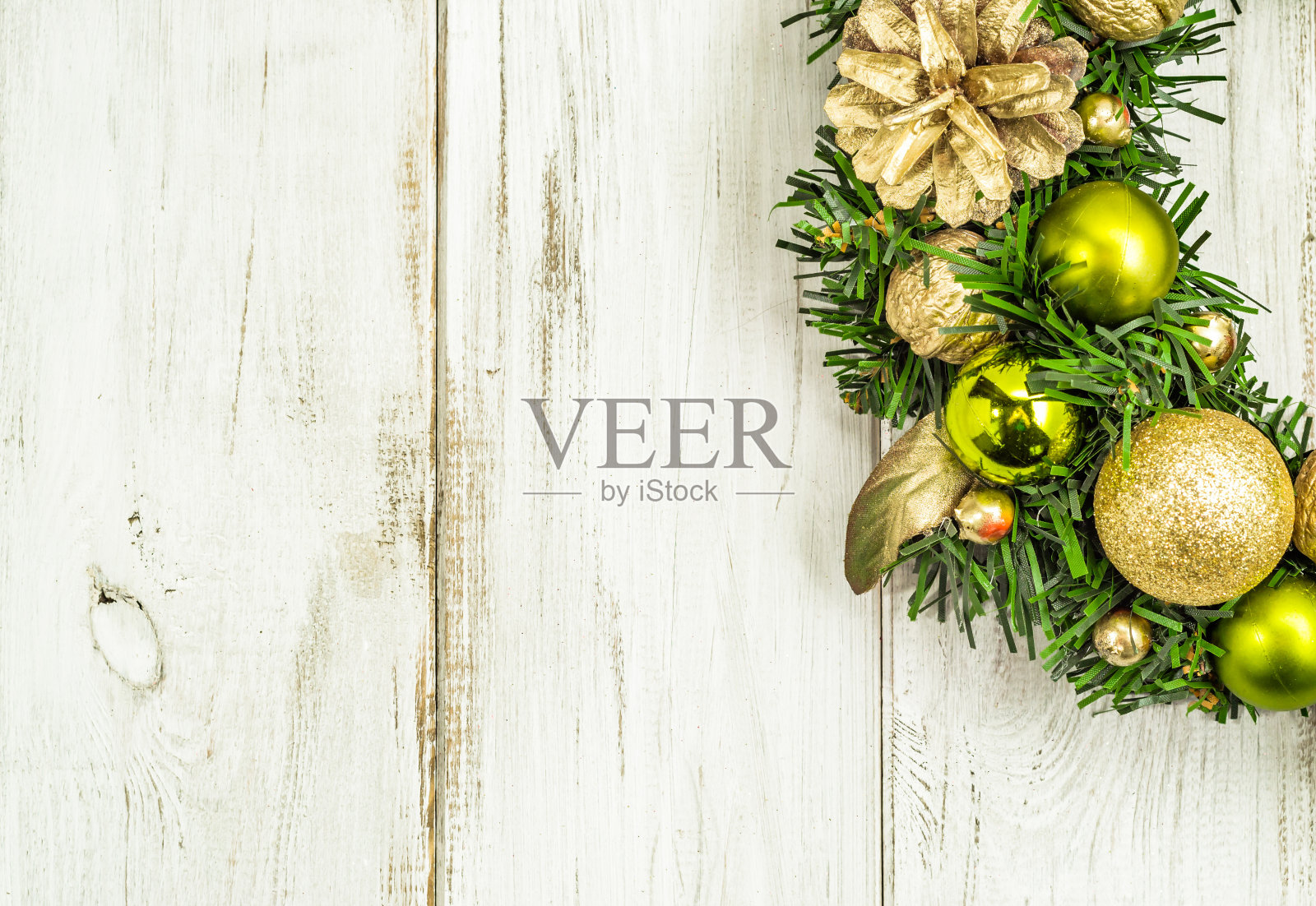 圣诞花环以木制为背景，用金饰装饰在绿色的杉木圣诞树上照片摄影图片