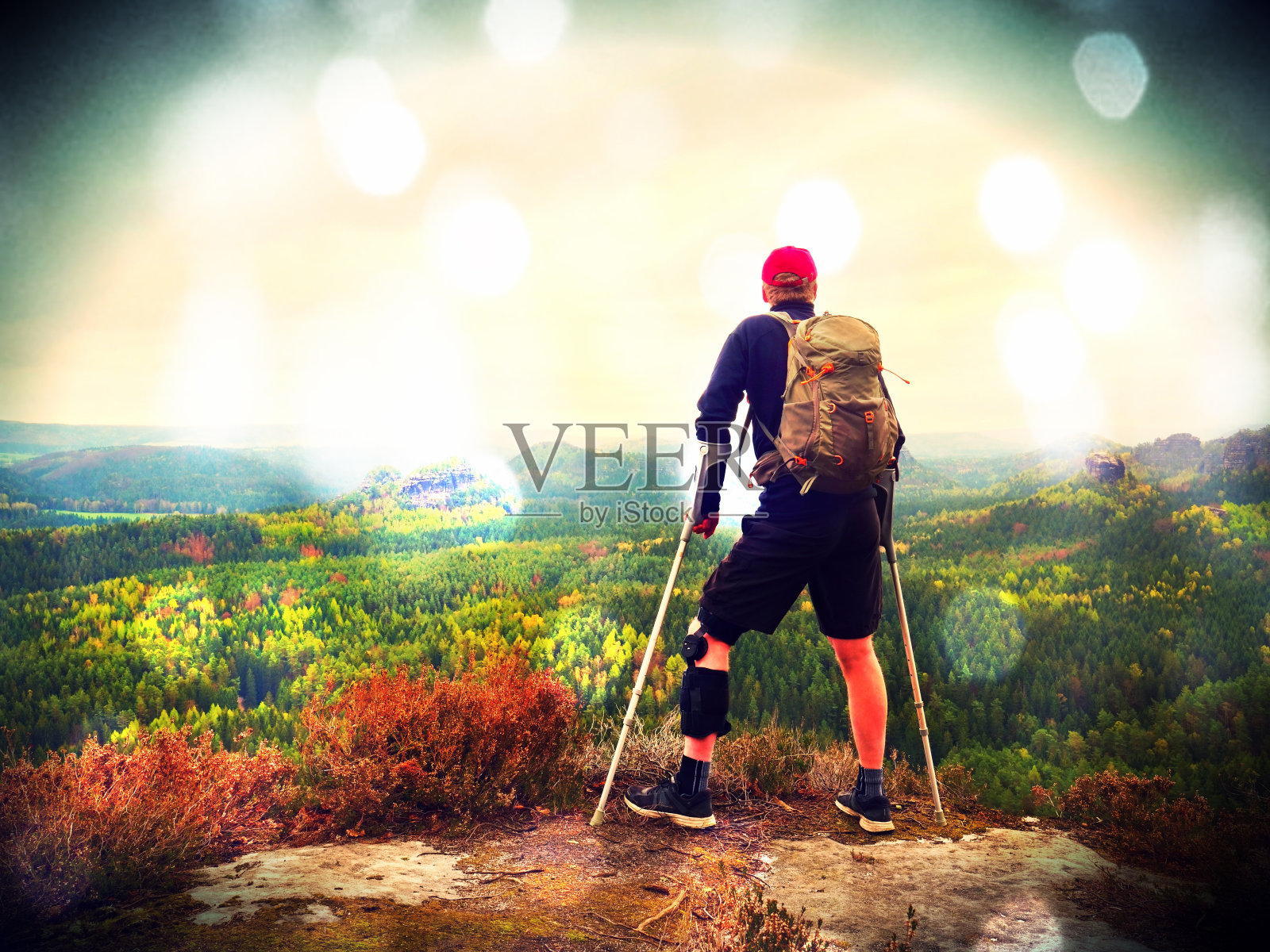 男徒步者穿支撑腿支架和对抗的cruthes。以自然森林公园为背景照片摄影图片