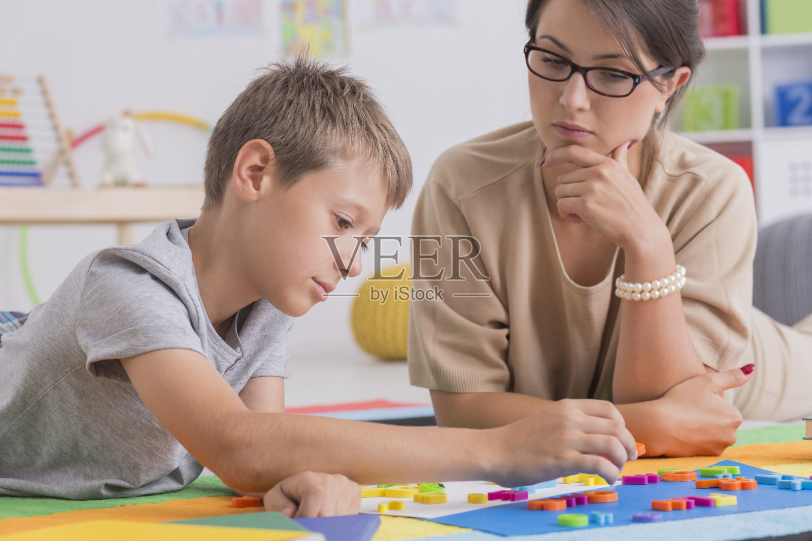 专注的男孩和漂亮的心理治疗师照片摄影图片