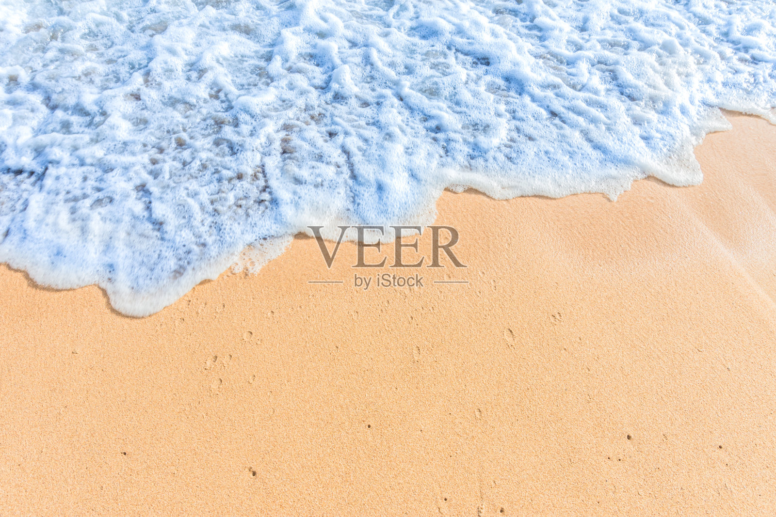 柔软的海浪和蓝色的海洋在沙滩上。照片摄影图片