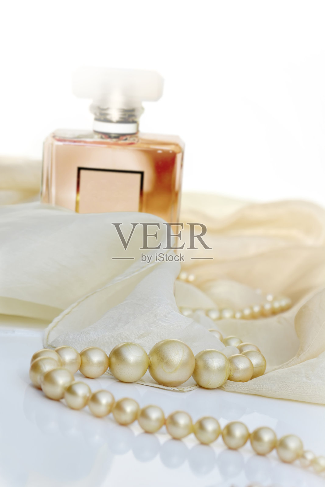 香水和珍珠在诱人的奶油缎子上照片摄影图片