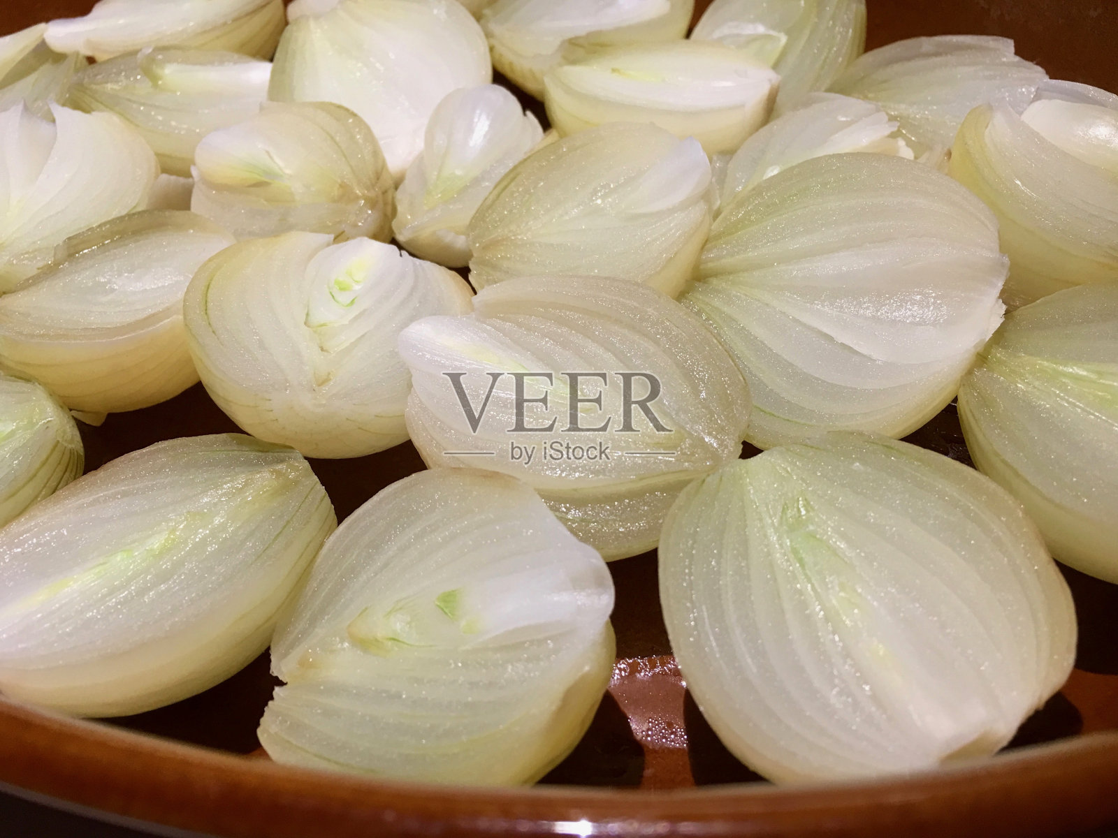 高角度观察烤盘里蒸熟的洋葱照片摄影图片