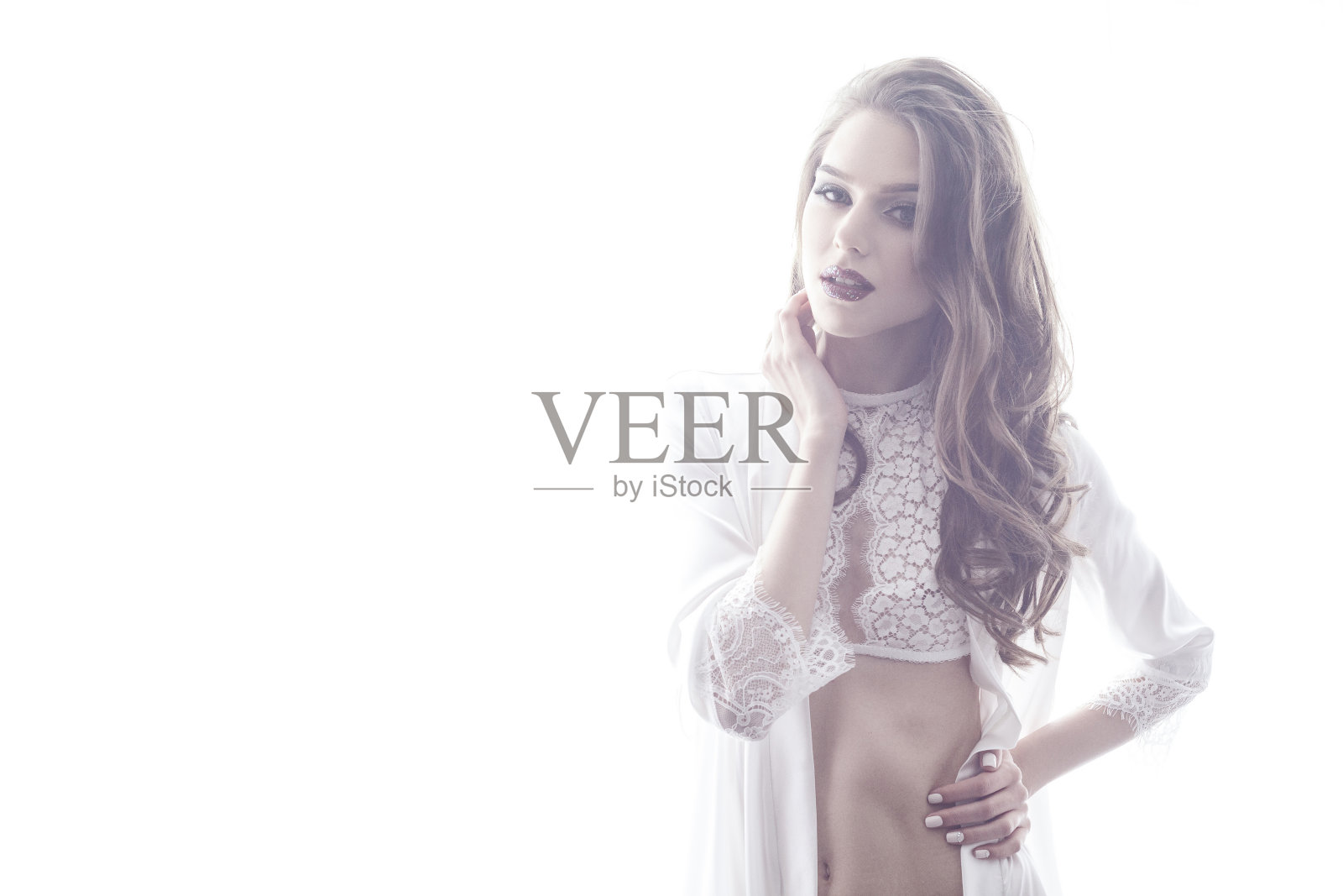 美丽性感的女士在优雅的白色长袍。近距离拍摄室内模特的时尚肖像。美丽的金发女人。迷人的女性身体在蕾丝内衣。照片摄影图片