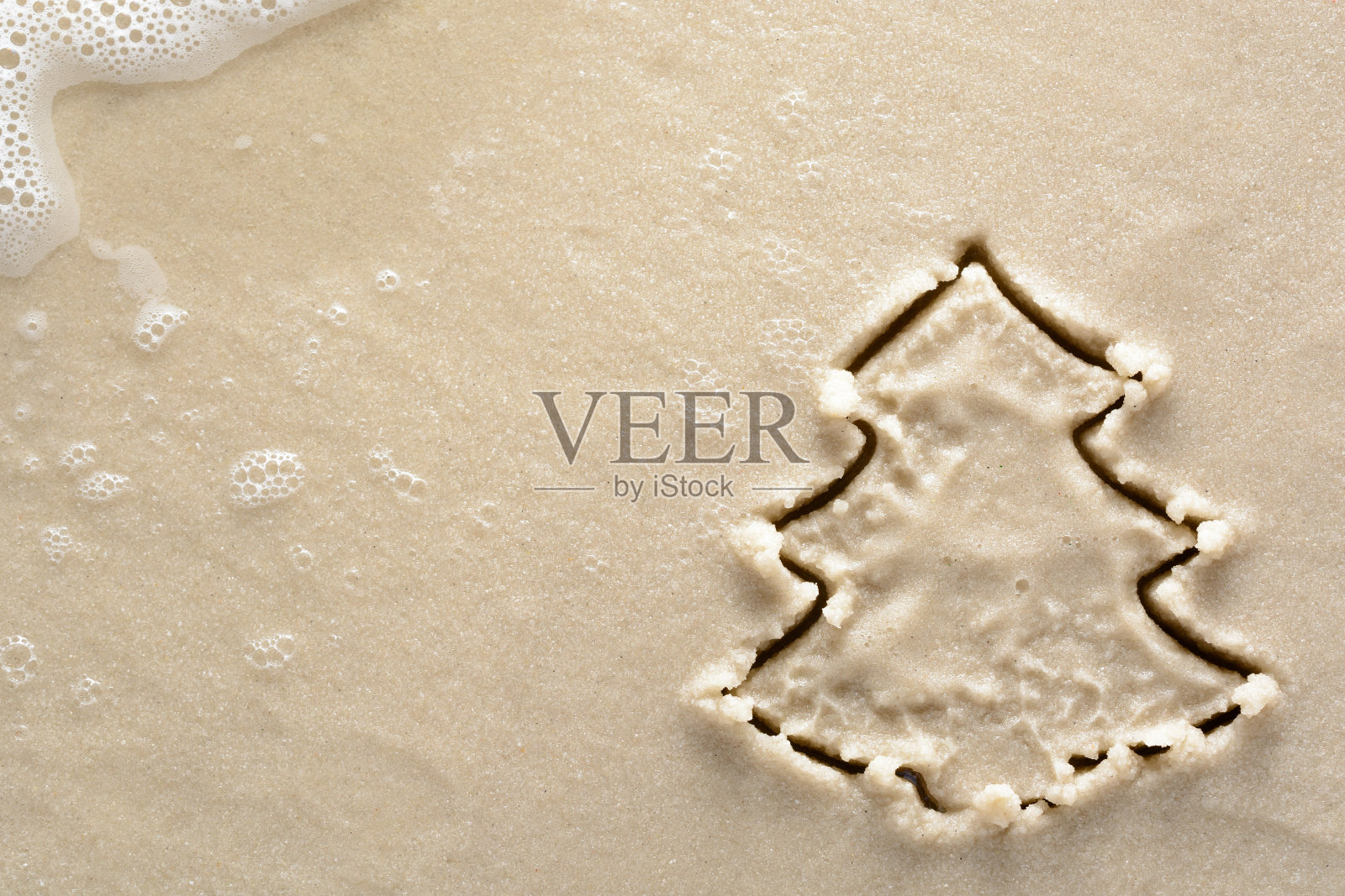 假日背景圣诞树画在沙滩上照片摄影图片