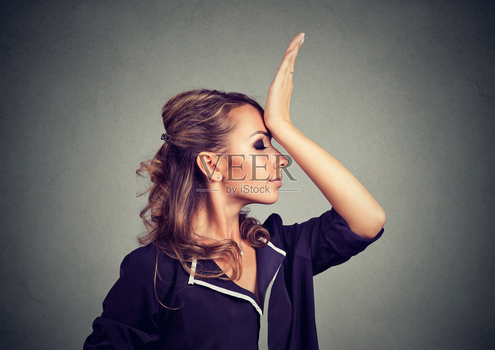 后悔做错了。悲伤的女人，拍手在头上有duh时刻孤立的灰色背景。消极的人类情感感觉，肢体语言照片摄影图片