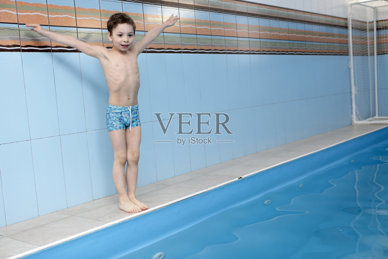 Сhild跳进游泳池照片摄影图片