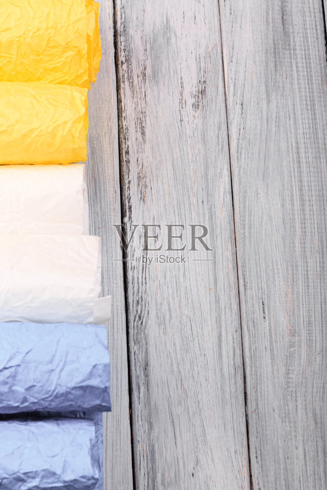 礼品彩色纸的俯视图，用于包装礼品的木质表面。照片摄影图片