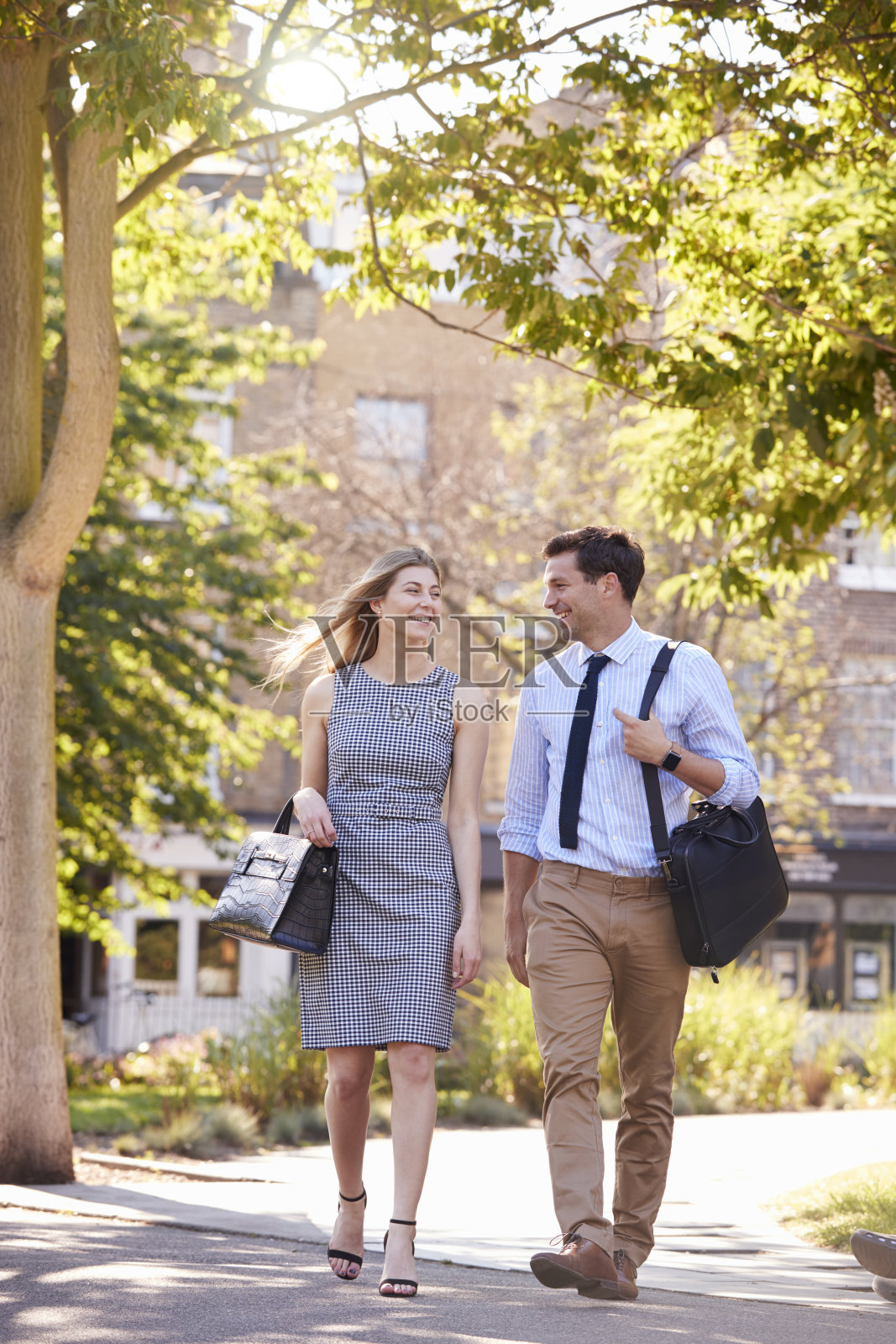 商人和女商人穿过城市公园步行上班照片摄影图片
