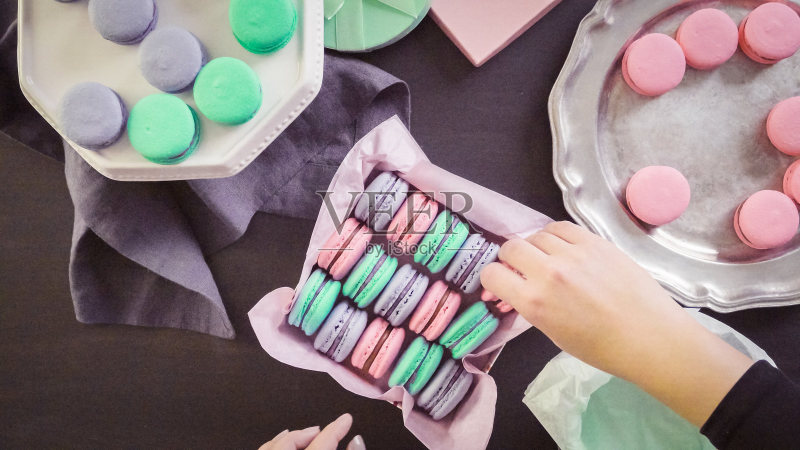 将法式马卡龙包装成礼盒。照片摄影图片