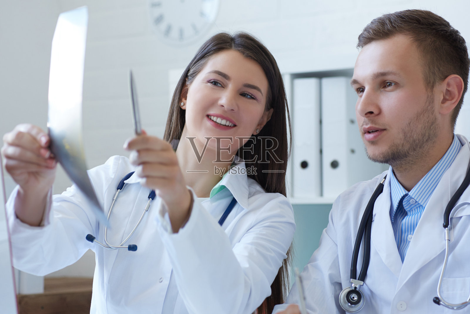 男女医生讨论x光影像。照片摄影图片