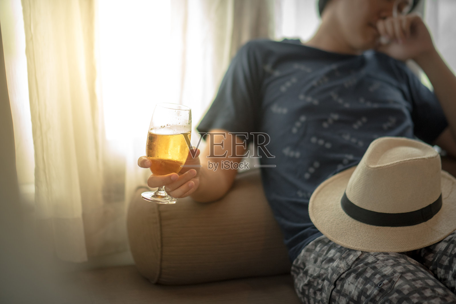 醉酒的男人在卧室里抱着一杯啤酒睡觉照片摄影图片