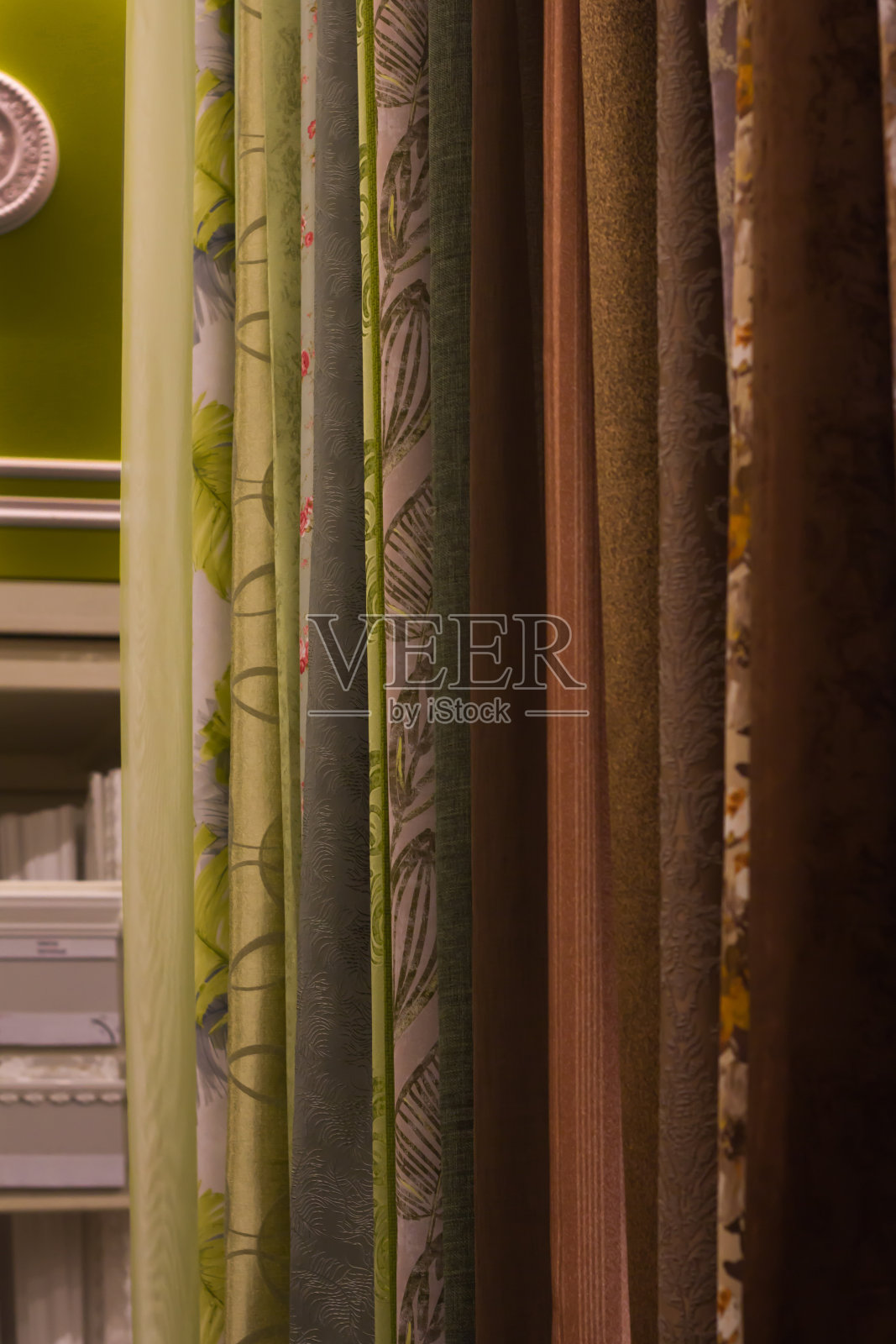 各种各样的漂亮窗帘挂样品在商店直立近距离照片摄影图片