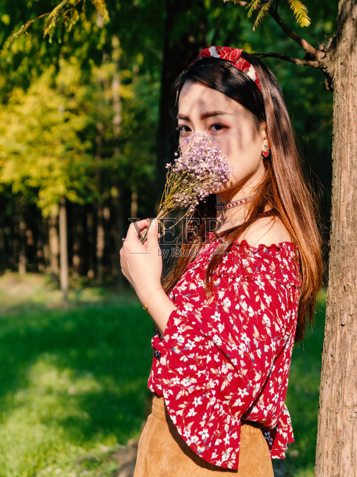 美丽的中国女孩在森林公园在一个阳光明媚的秋天下午，复古的电影模式。照片摄影图片