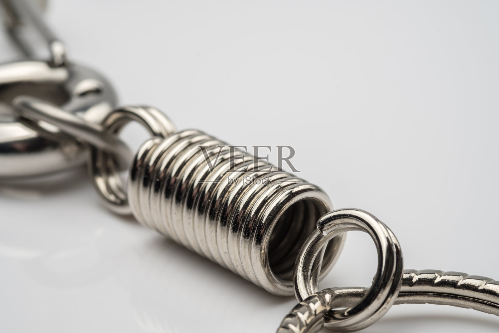 白色背景上的银色钥匙链或钥匙圈照片摄影图片