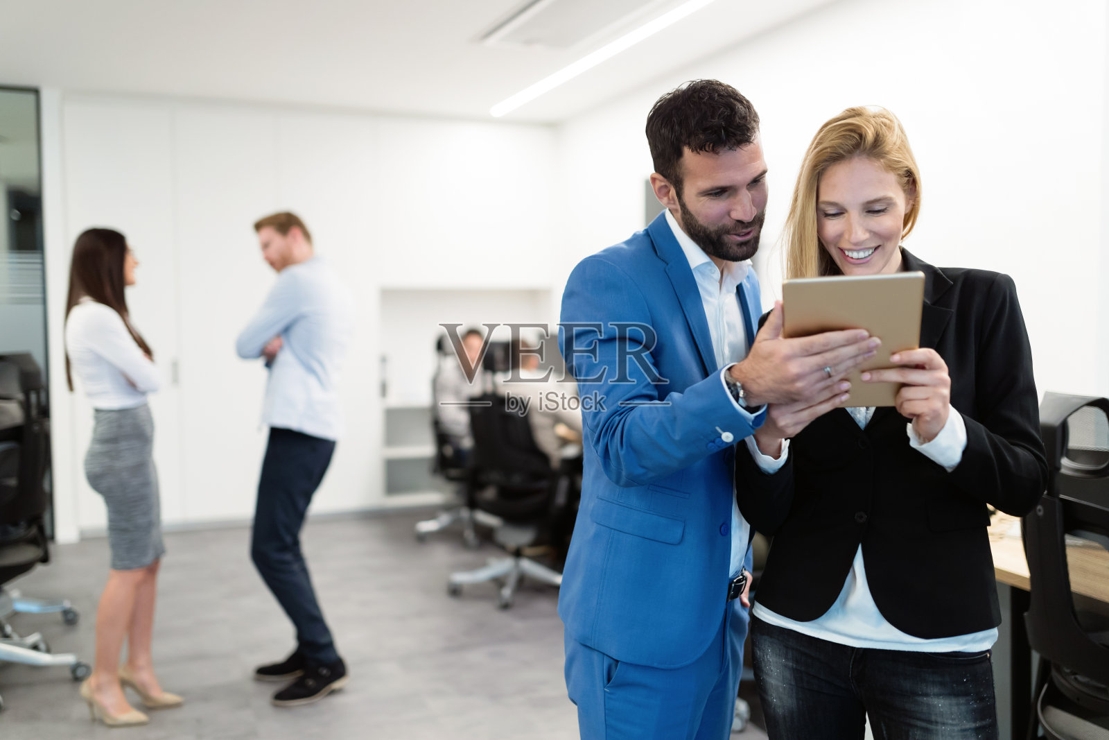 迷人的商业夫妇在现代办公室使用平板电脑照片摄影图片