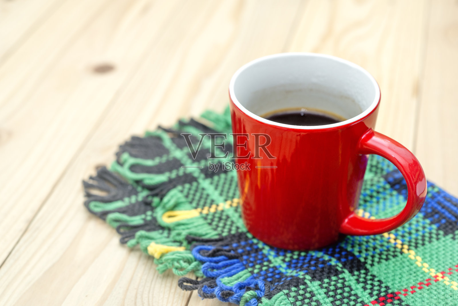 木桌上放着一杯红咖啡。照片摄影图片