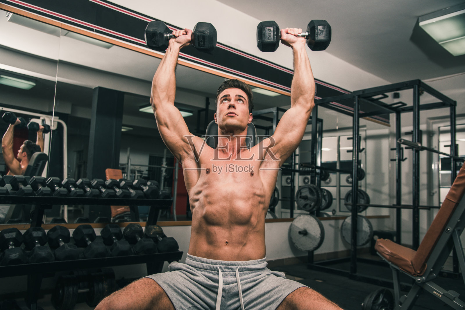 运动员把两个哑铃举过头顶照片摄影图片