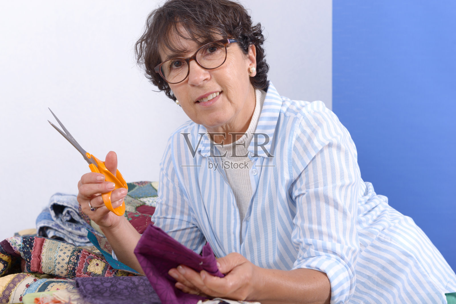 一个正在缝拼布的成熟的黑发女人照片摄影图片