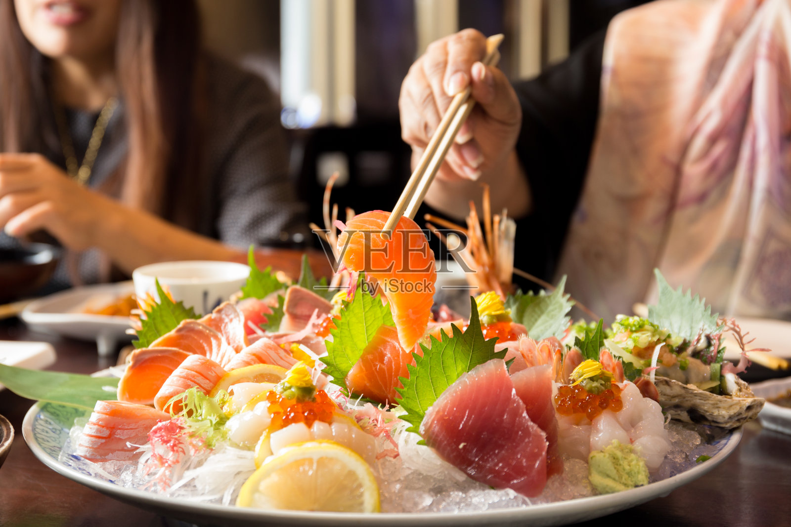 用筷子夹着三文鱼寿司照片摄影图片