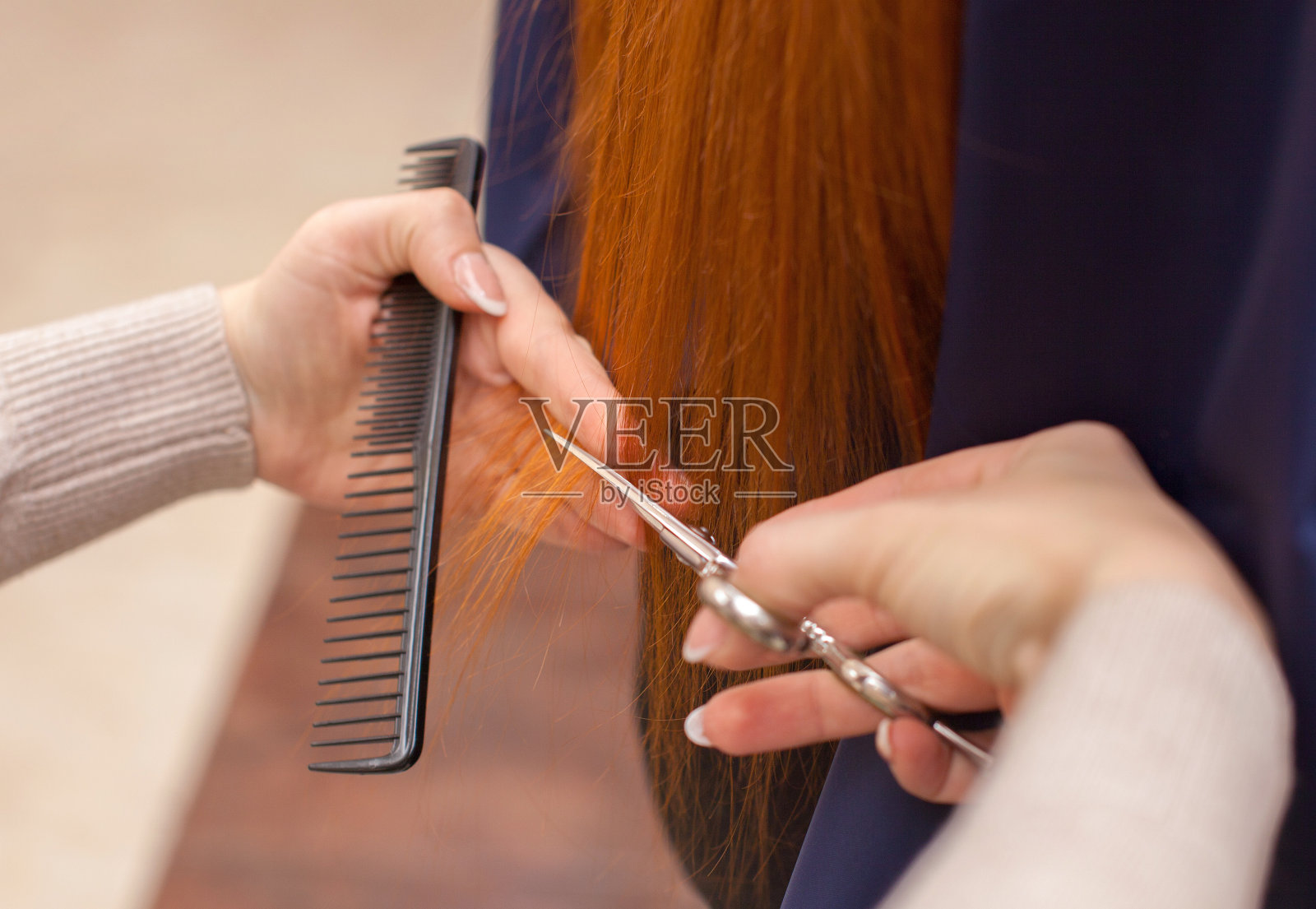 理发师用剪刀给一个红头发的姑娘理发照片摄影图片