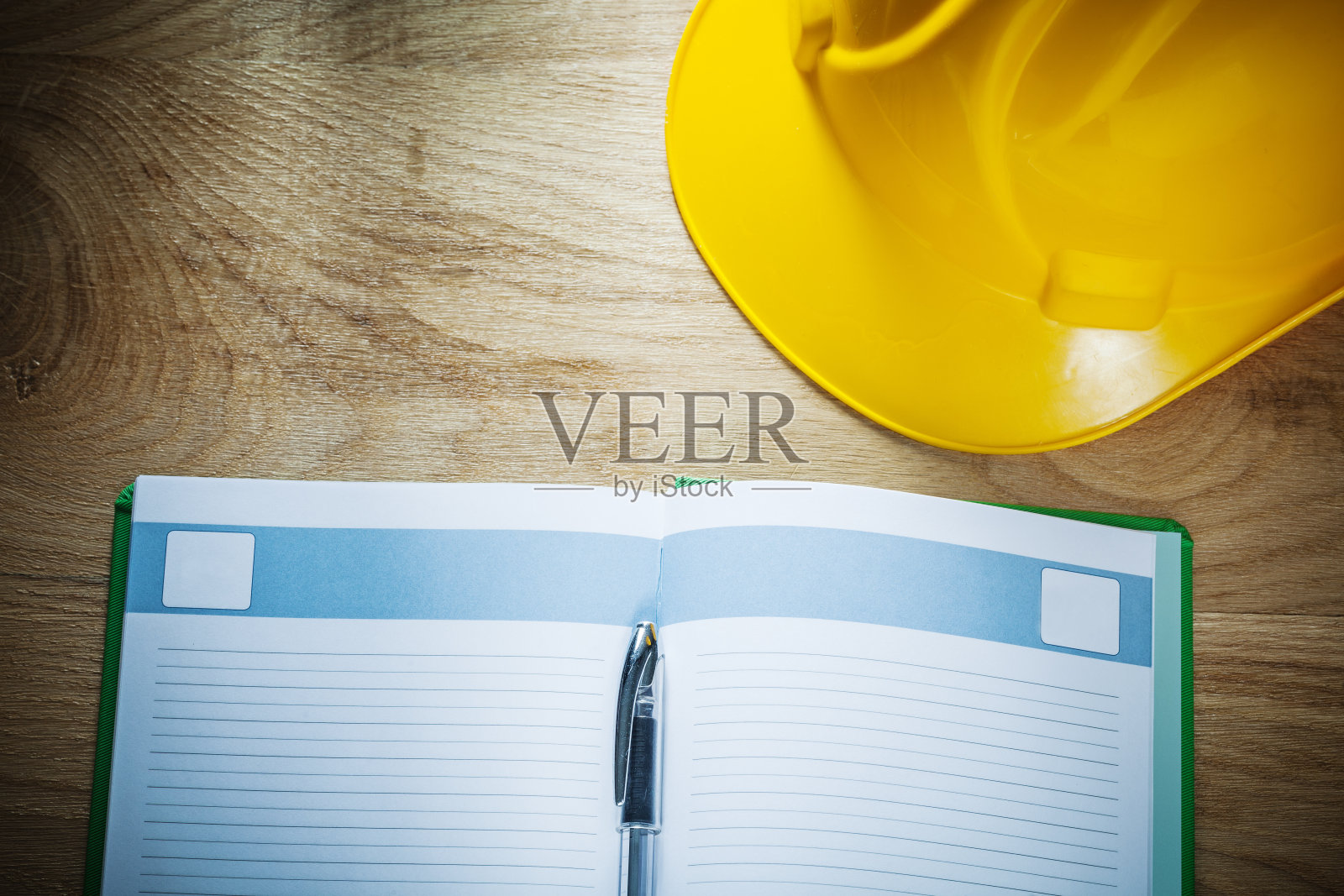 打开笔记本笔在木板上建造头盔照片摄影图片