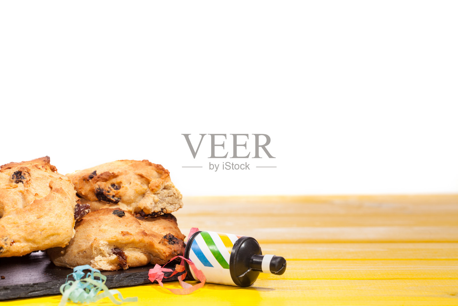 派对的食物。黄色的桌子上放着简单的自制蛋糕，上面挂着派对彩带。照片摄影图片