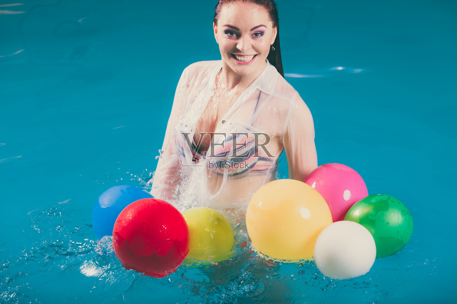 快乐的女人在水里玩气球照片摄影图片