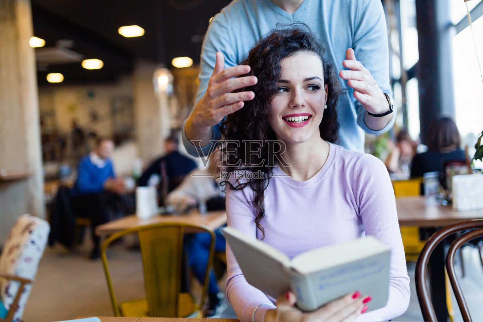 一对年轻夫妇在咖啡店看书照片摄影图片