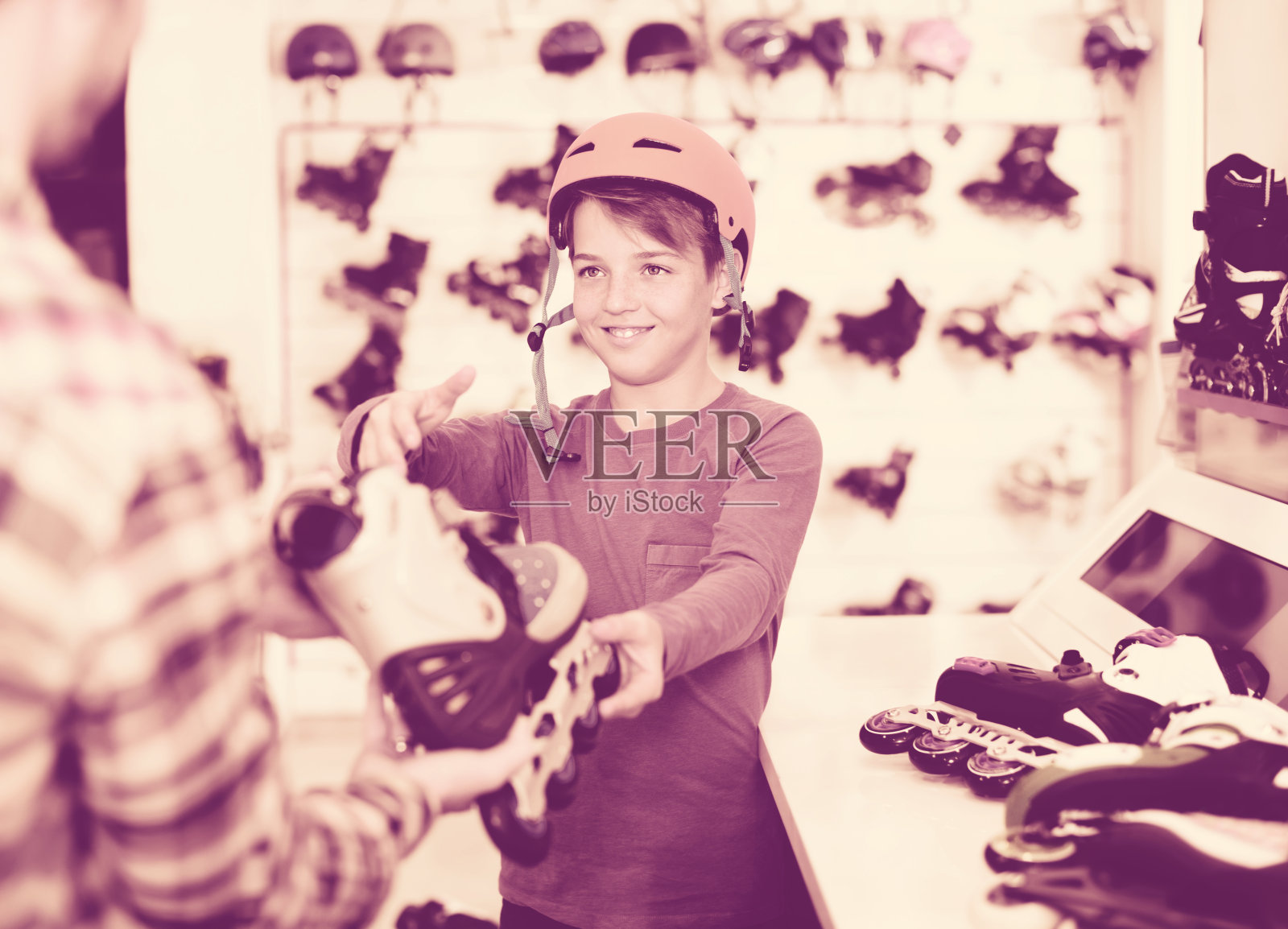 男子向男孩展示旱冰鞋照片摄影图片