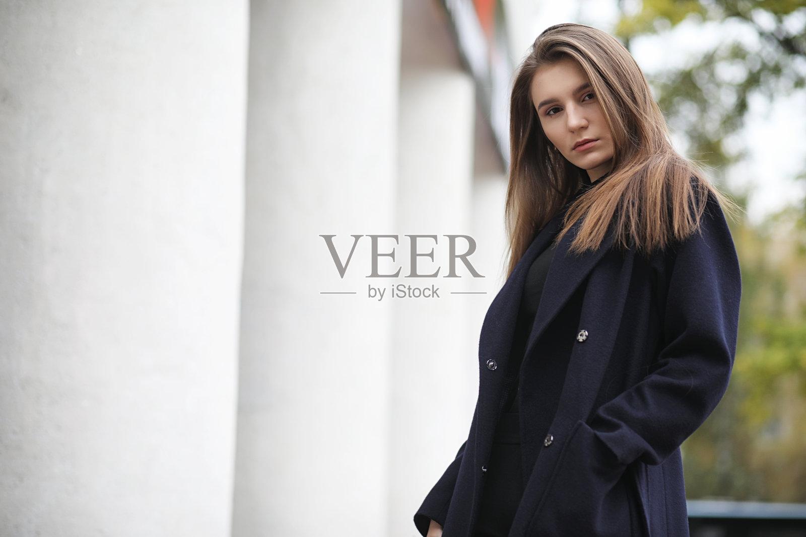 在商业区穿着外套的漂亮女孩照片摄影图片