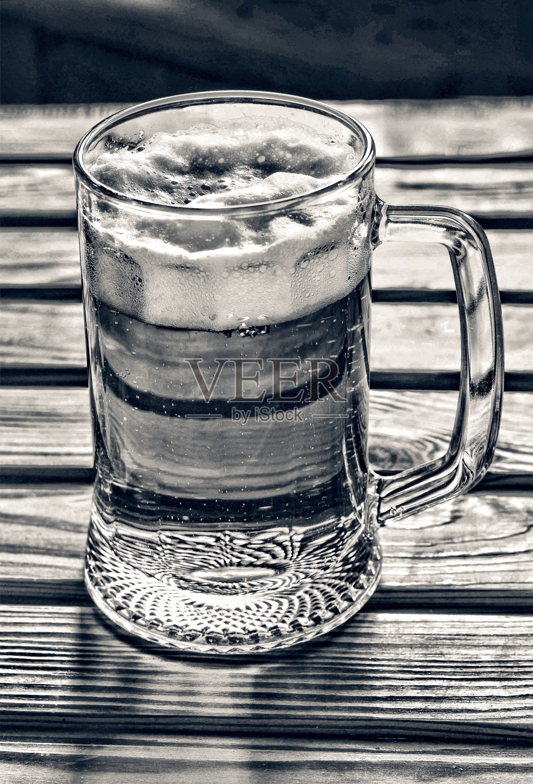 酒吧的木桌上放着一大杯淡啤酒泡沫丸照片摄影图片