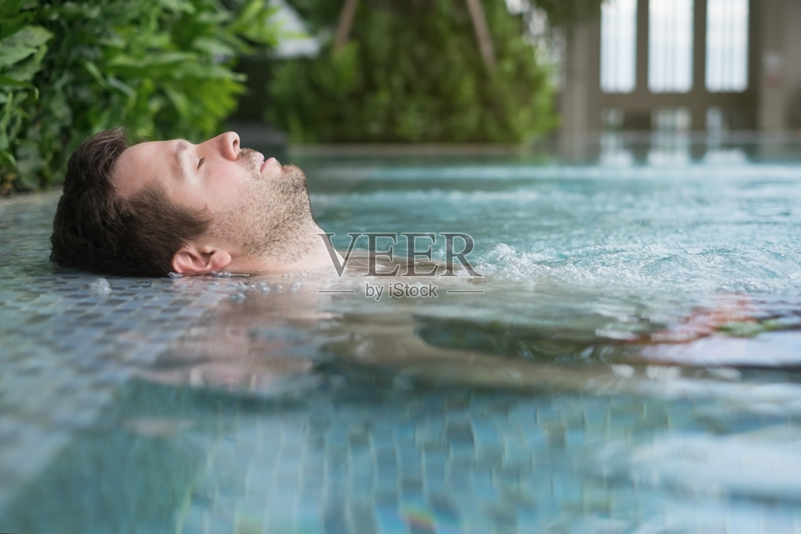 一个白人男人在游泳池里。照片摄影图片