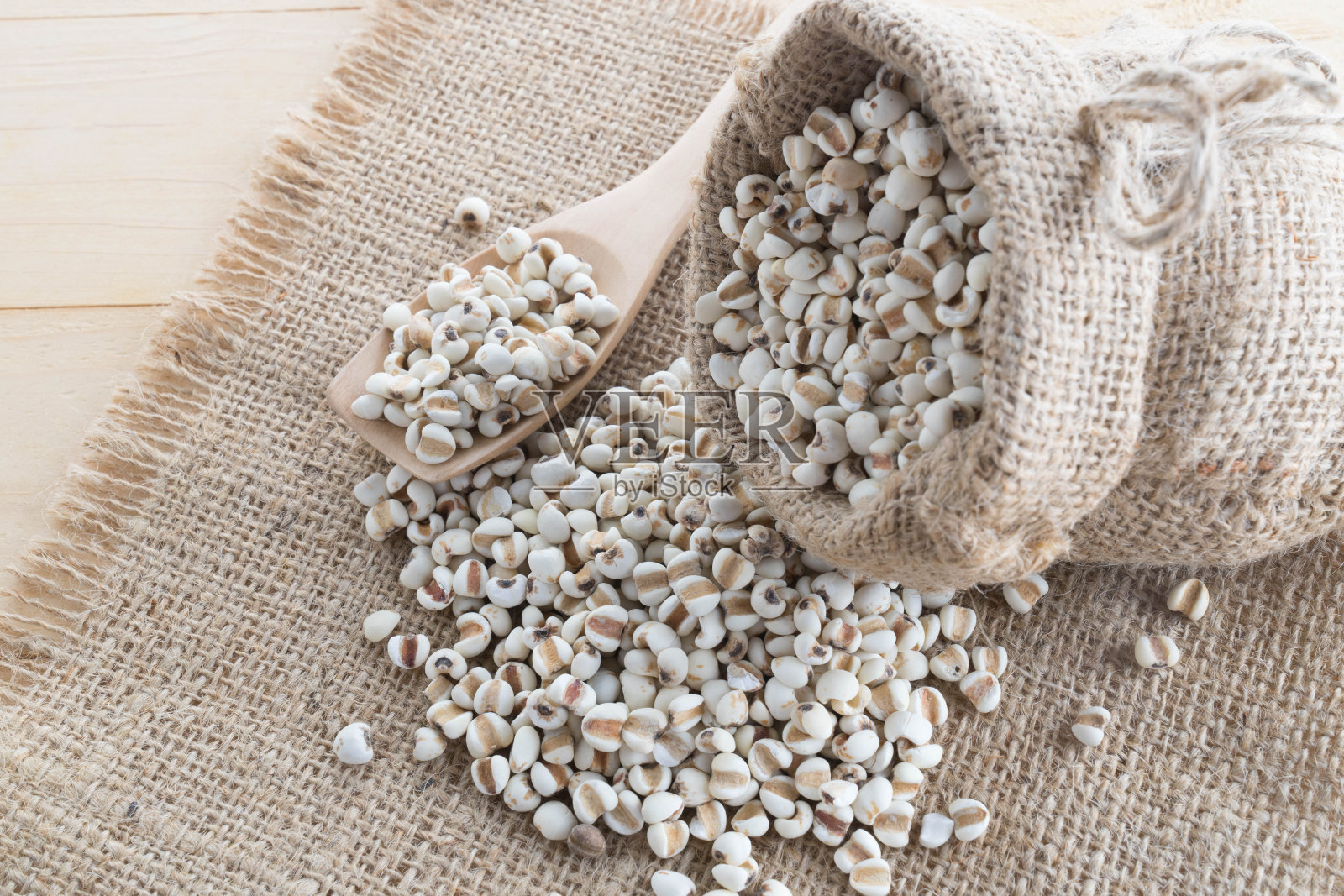 小米放在麻袋上，背景是木头照片摄影图片