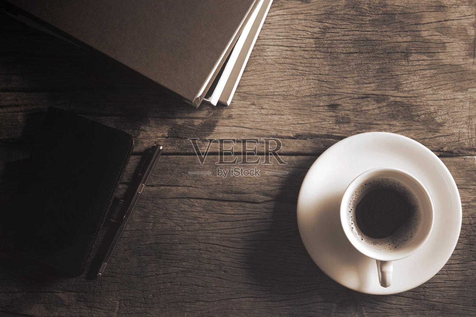 书、笔、皮包和咖啡杯放在木地板上。照片摄影图片