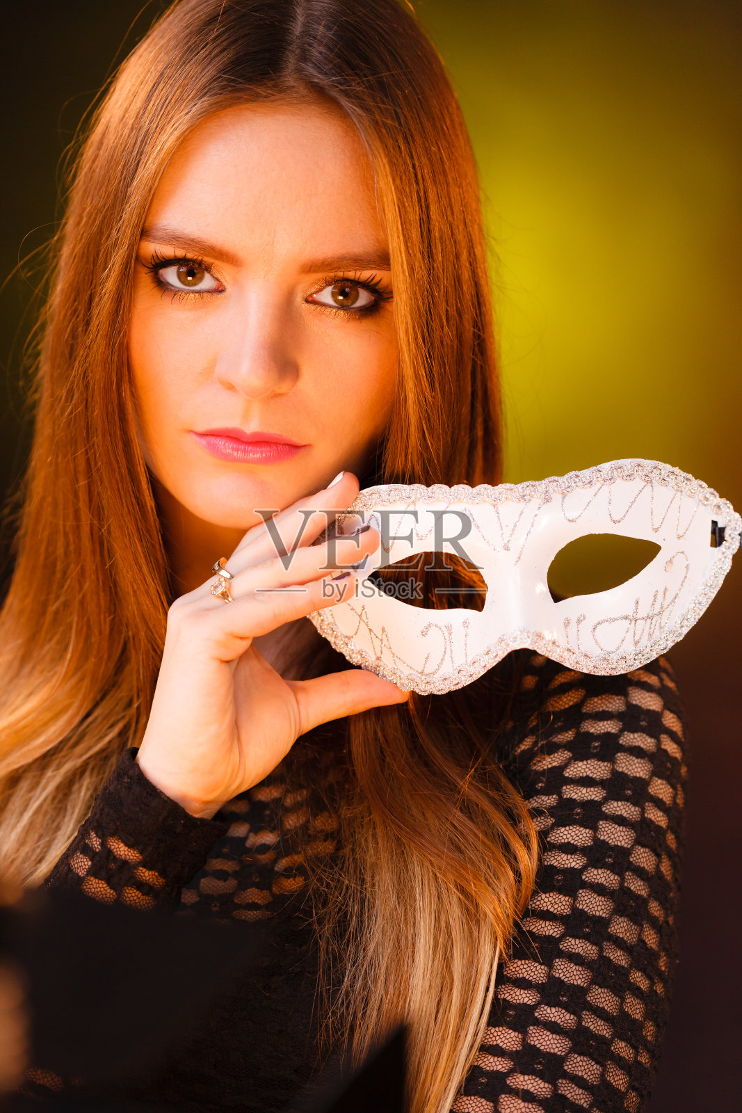 性感淑女捧狂欢节面具。照片摄影图片