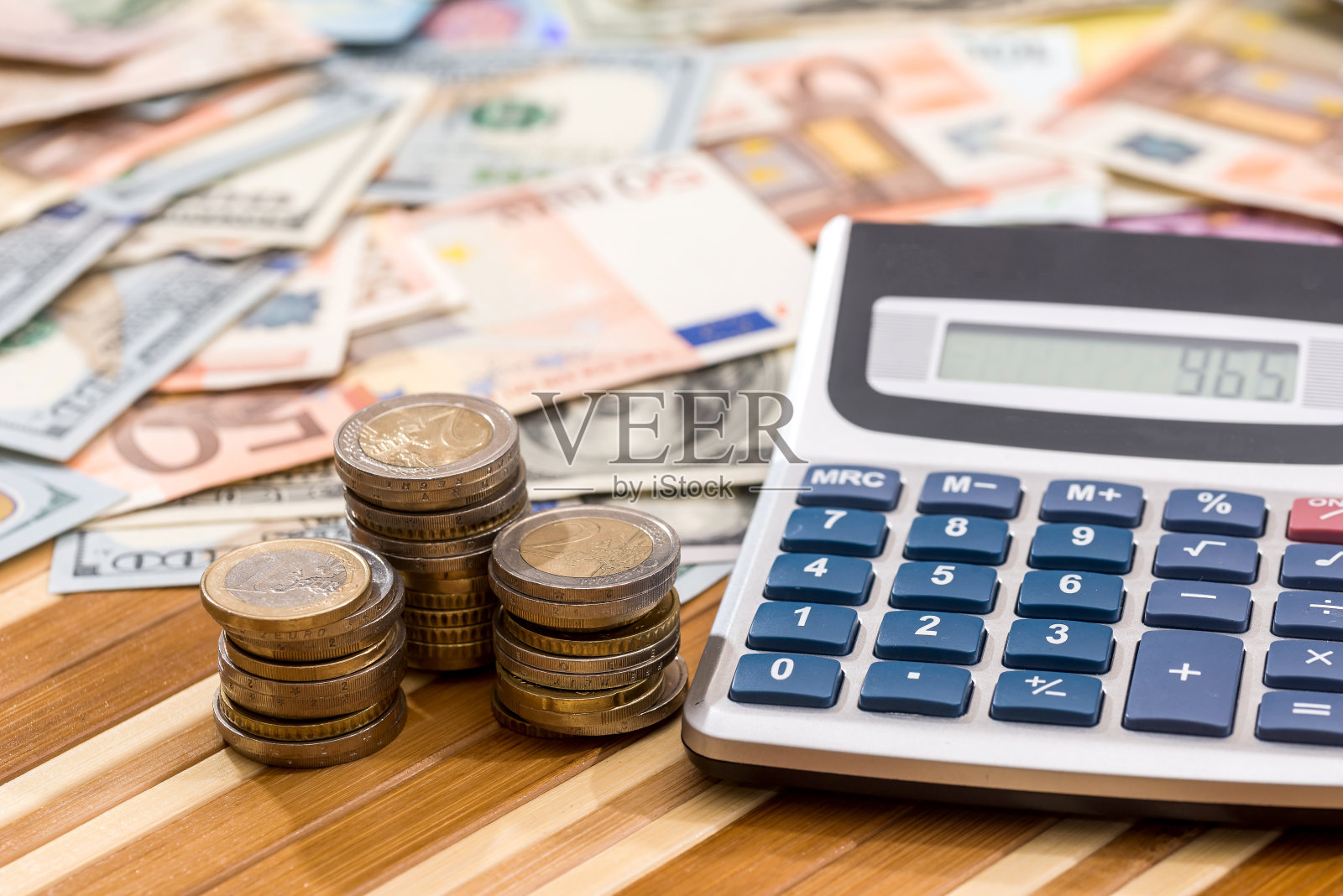 美元和欧元的纸币，带有硬币和计算器。照片摄影图片