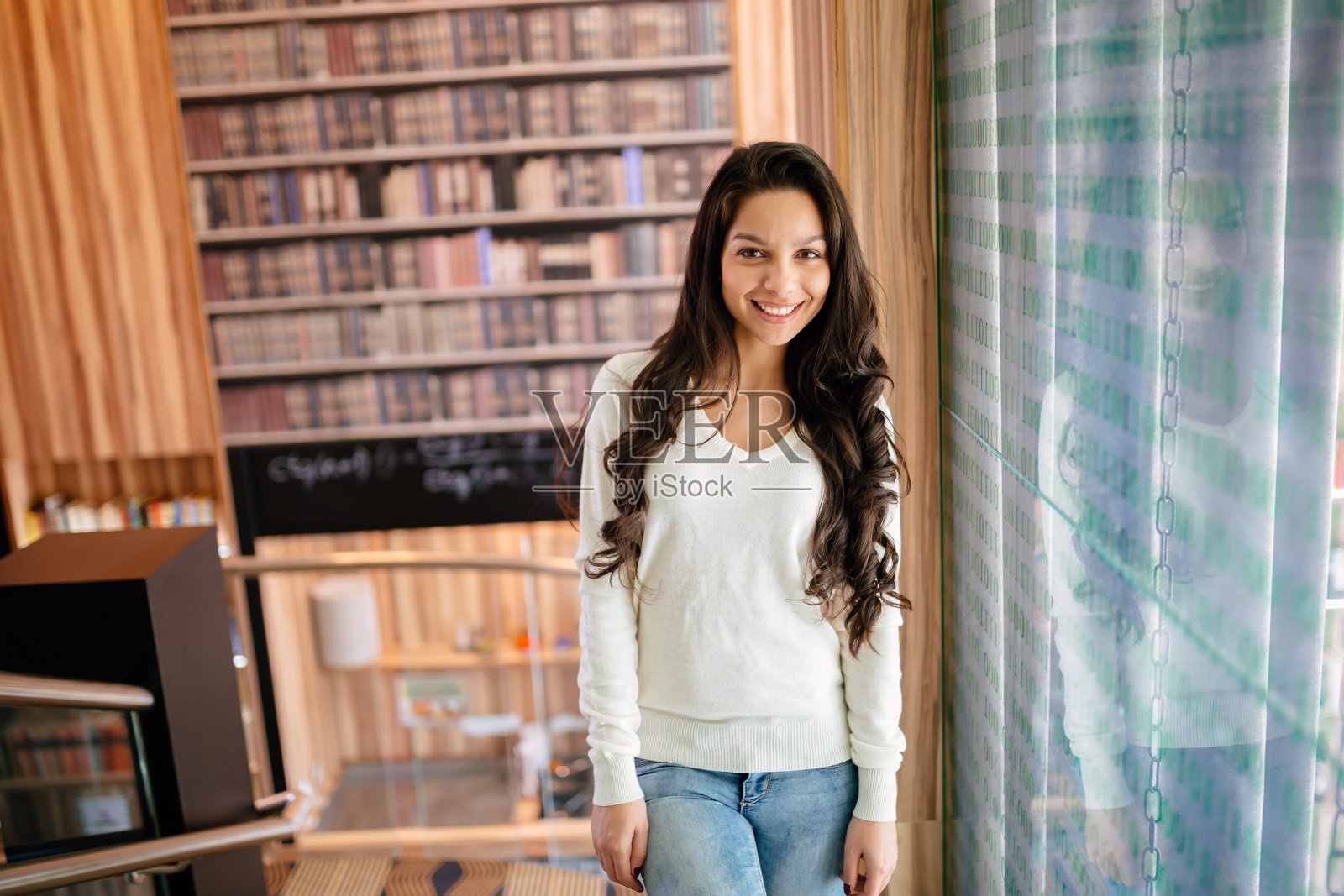 漂亮的黑发女子在图书馆照片摄影图片