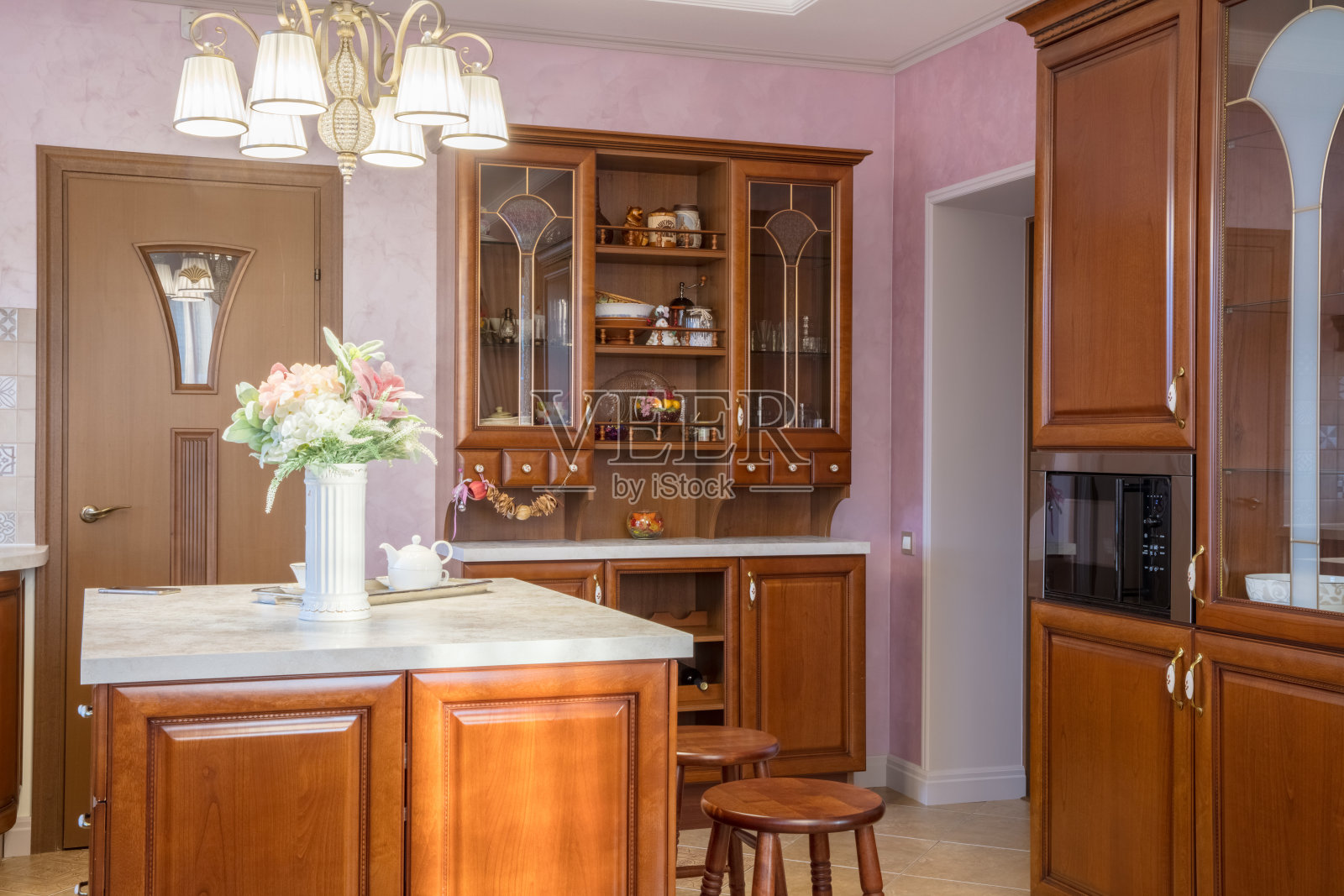 浅色经典厨房中的橱柜，桌上有花瓶和鲜花照片摄影图片