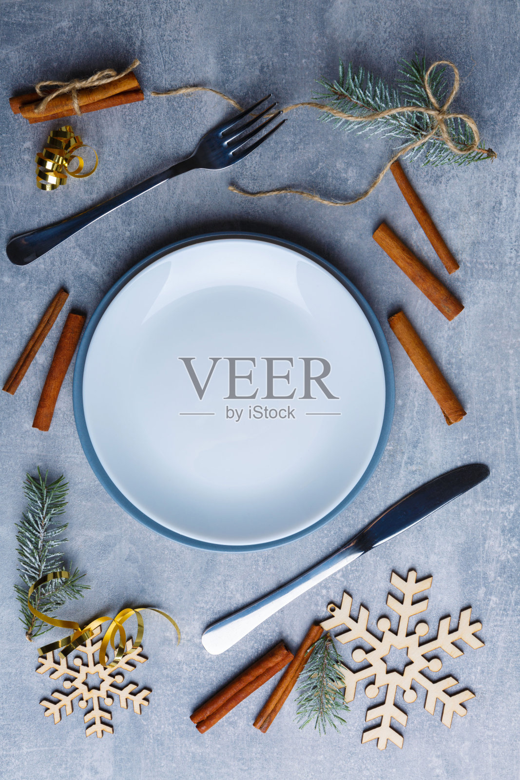 有餐具的盘子，肉桂粉，圣诞树和雪花。照片摄影图片