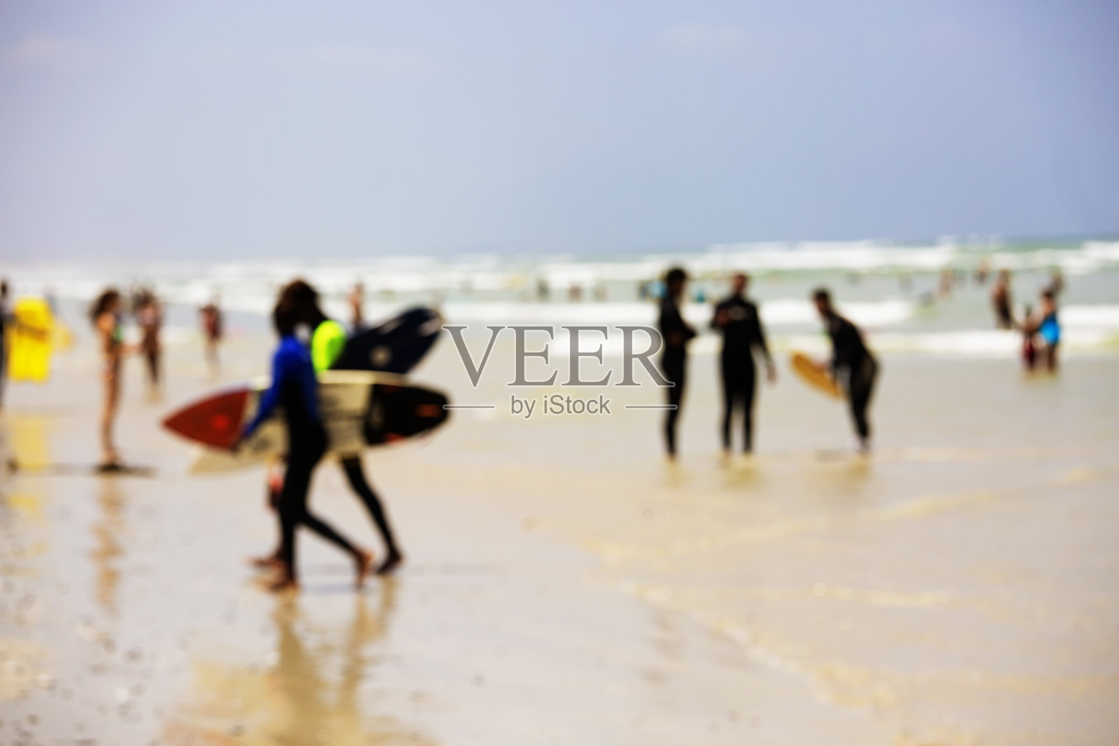 冲浪者离开海滩的水的散焦照片照片摄影图片