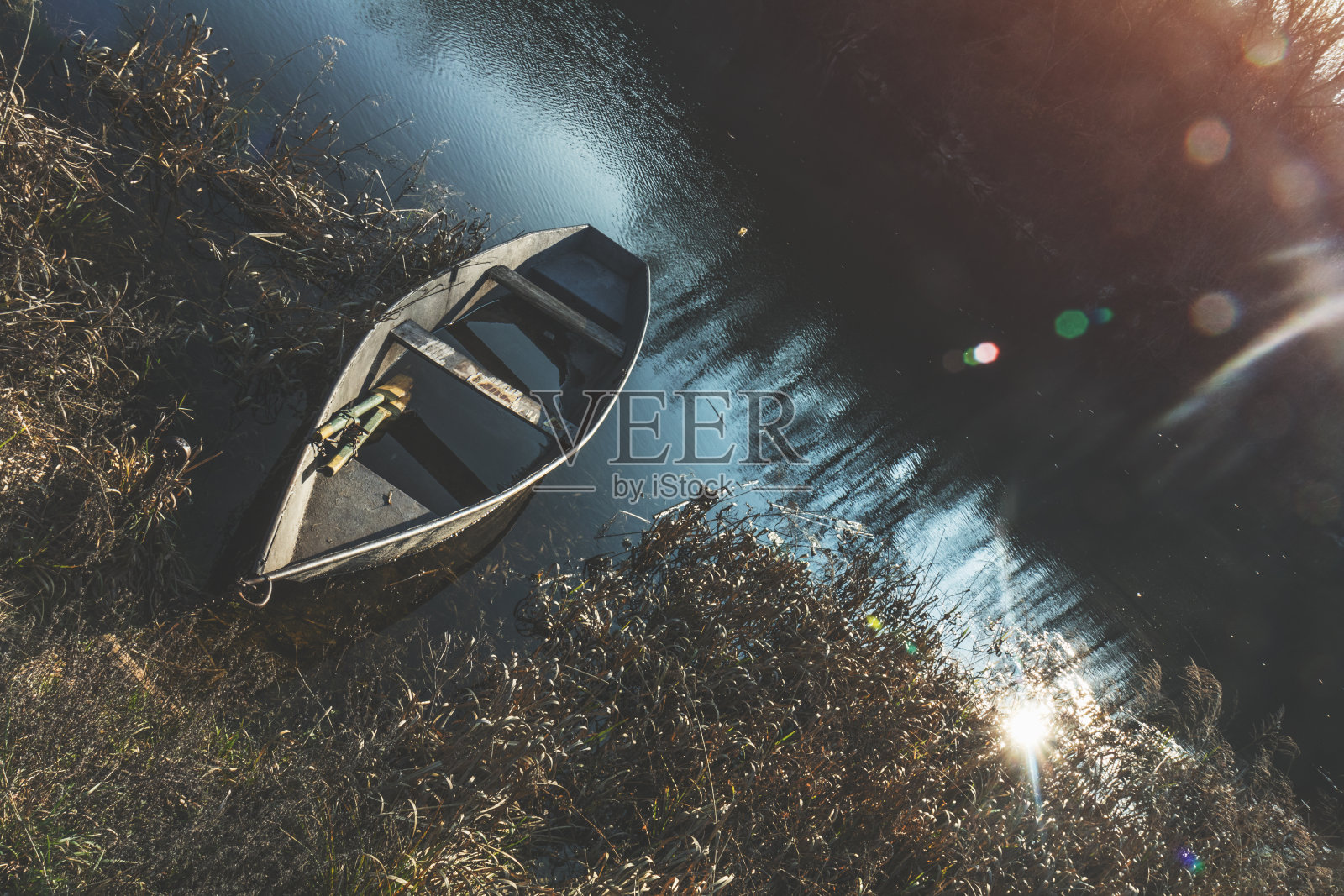 木船在秋日的夕阳下平静地停泊在江水上照片摄影图片